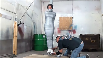 Ample-Breasted Woman Bound To A Pole With Adhesive