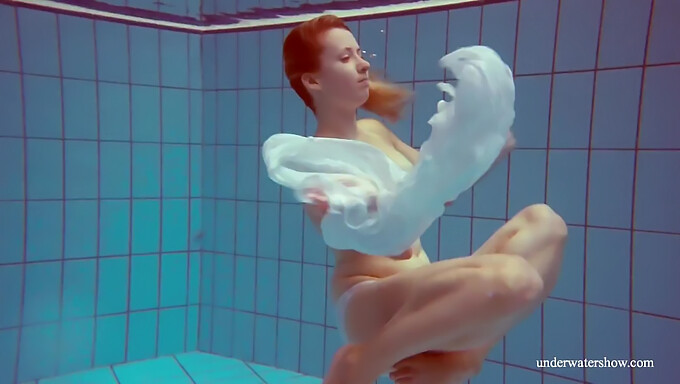 Melisa Darkova, a fiery redhead teen, indulges in a solo nude swim